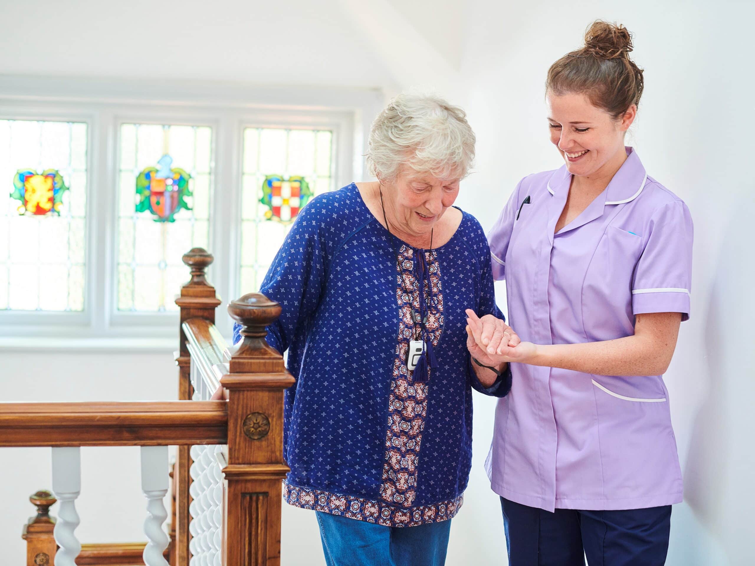 nurse helping senior woman climb the stairs of her home