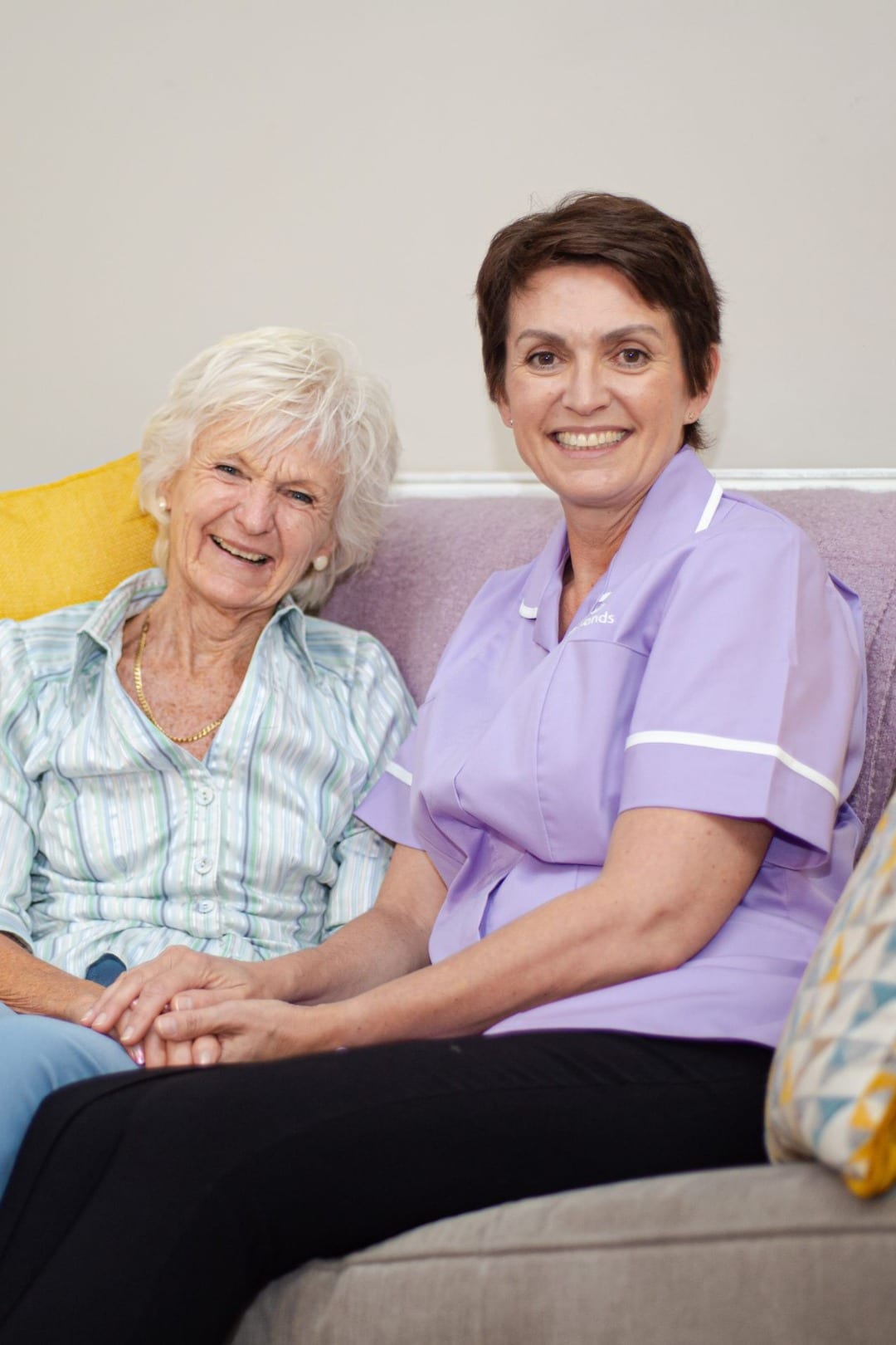 a women working in adult care smiling with an elderly lady